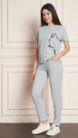 Women's light grey Lycra blend tracksuit with a black cat print on the t-shirt.
• A woman modeling a comfortable grey tracksuit with an animal print design, perfect for loungewear or casual outfits.
• Full-length view of a light grey tracksuit featuring a unique cat graphic on the top and matching bottoms.